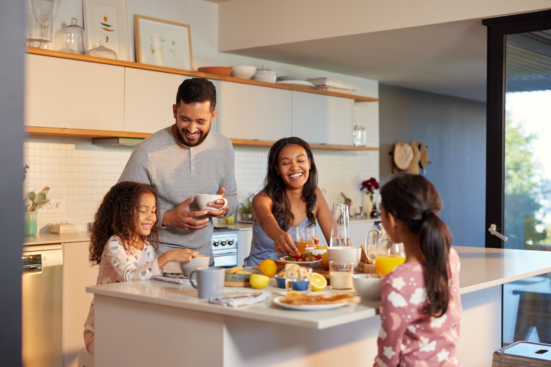 Happy multiethnic family enjoying healthy breakfast