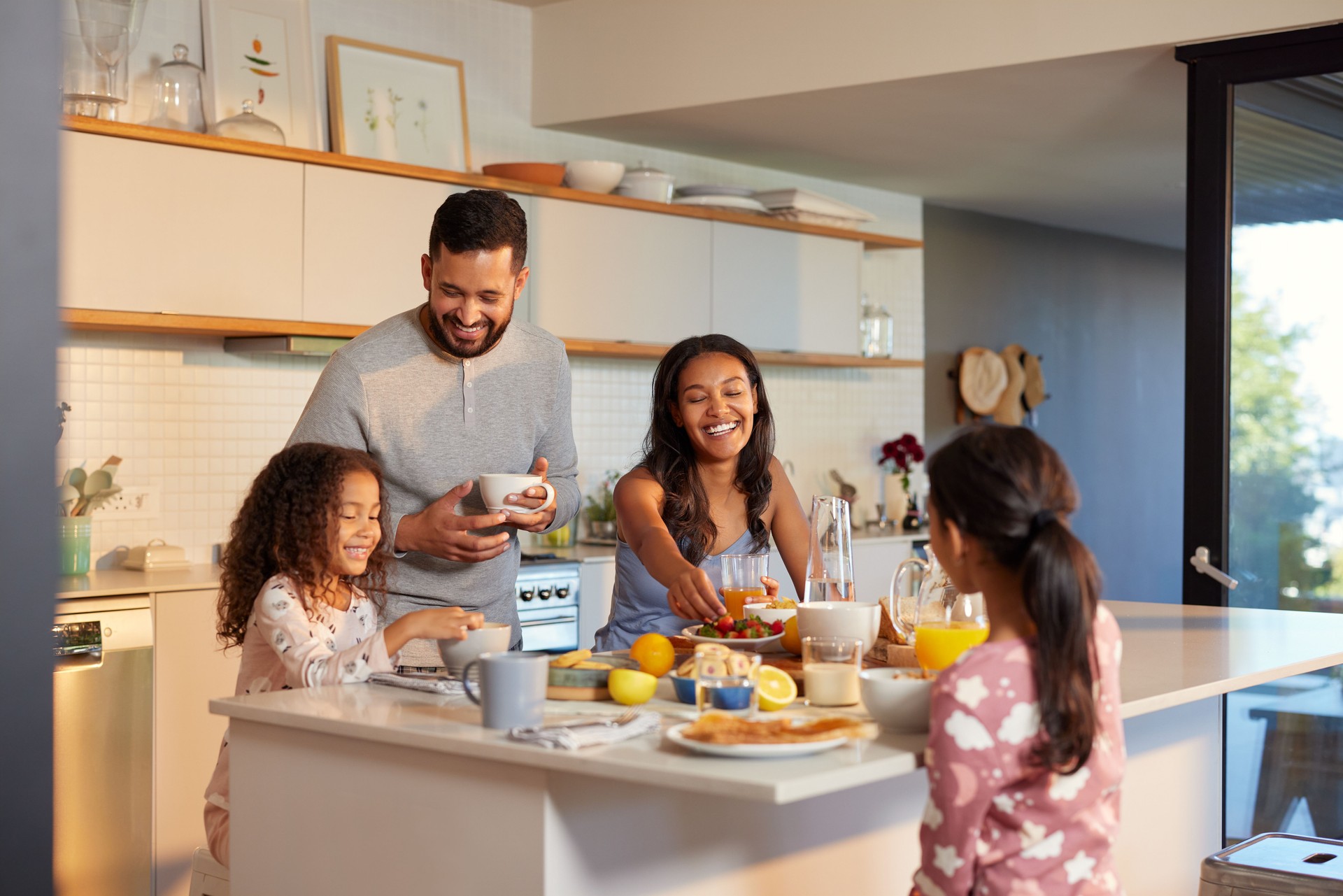Happy multiethnic family enjoying healthy breakfast